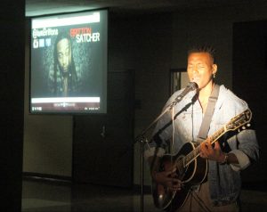 A guest artist performs an original song at post-show concert after the Noir Fashion Show Friday.
