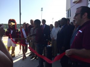 Running back Tyler Cain cuts the ribbon at the new football end zone facility (field house) opening Tuesday.